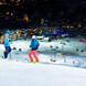 Skifahrer bei Nacht auf der Skipiste mit Blick ins Tal